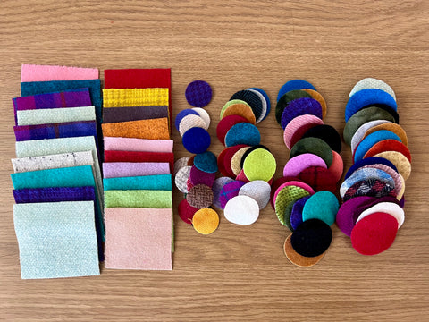 Photo of an assortment of wool square pieces and die cut circles for wool appliqué.