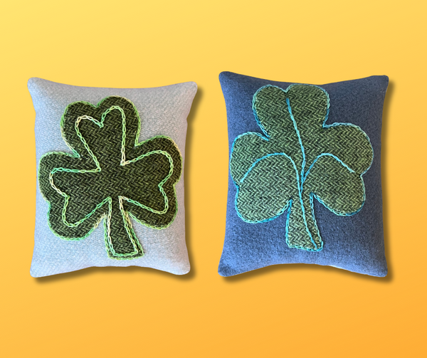 Photo of a double-sided pincushion with a wool appliqué shamrock embellished with perle cotton.