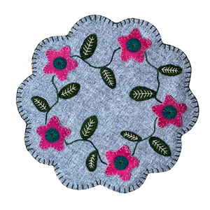 Wool applique candle mat with pink flowers and leaves with scalloped mat and blanket stitch border