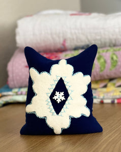 Photo of a wool appliqué pincushion with embroidery - part of a free pattern series.