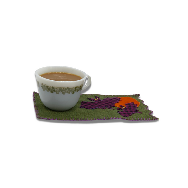 Bat and moon mug rug with cup of tea on top.