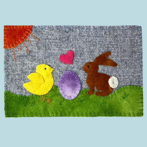 picture of an easter wool applique mug rug with a bunny and a chick and an egg between them